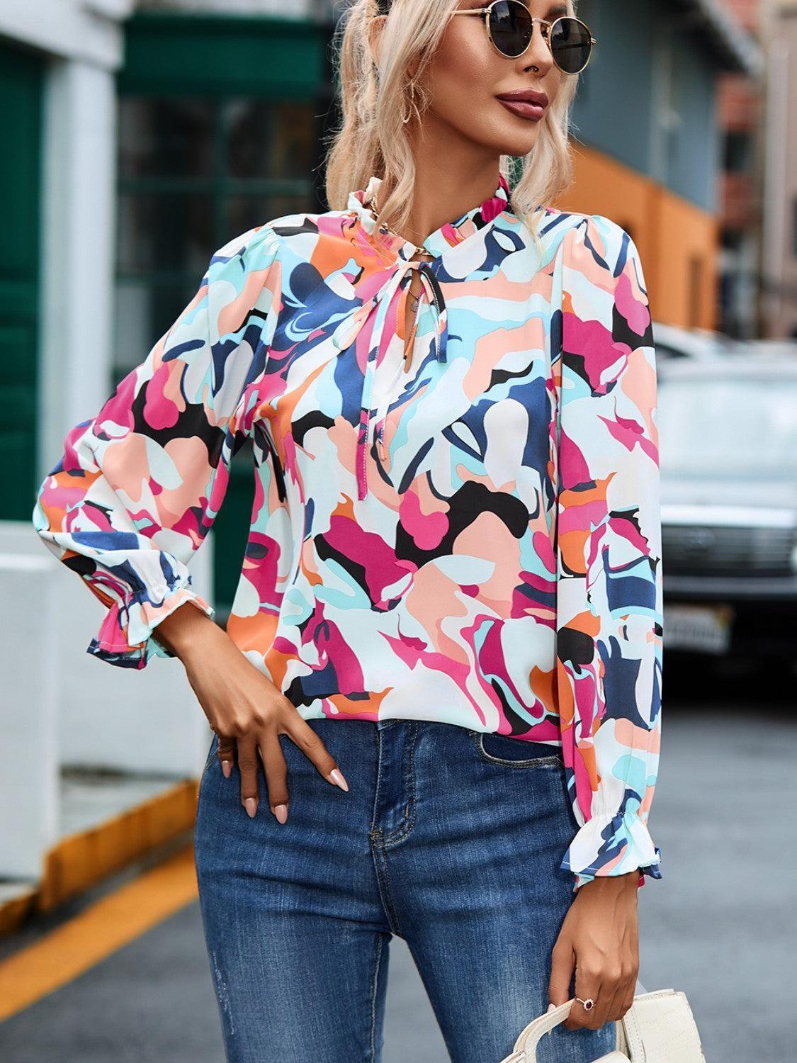 a woman wearing a colorful blouse and jeans
