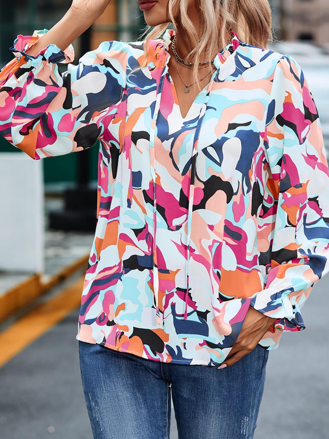 a woman wearing a colorful shirt and jeans