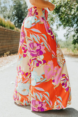 a woman in a long skirt is walking down the street