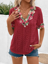 a woman wearing a red top with flowers on it