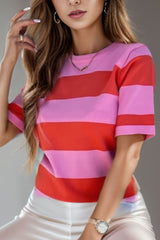 a woman in a pink and red striped shirt smoking a cigarette