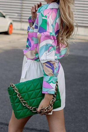 a woman walking down a street holding a green purse