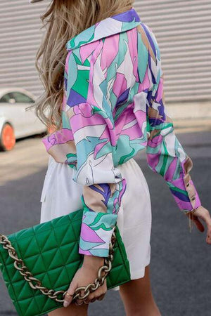 a woman carrying a green purse while walking down a street