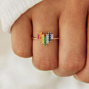 a woman's hand with a gold ring with multicolored stones