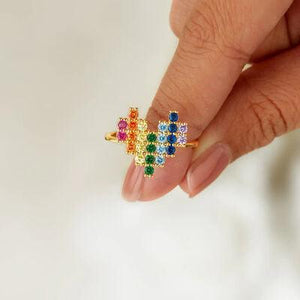 a woman's hand holding a multicolored ring