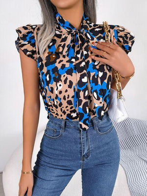 a woman wearing a leopard print shirt and jeans