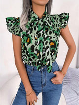 a woman wearing a green leopard print shirt