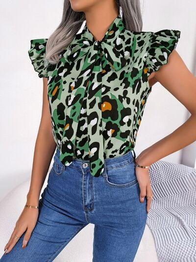 a woman with grey hair wearing a green leopard print blouse