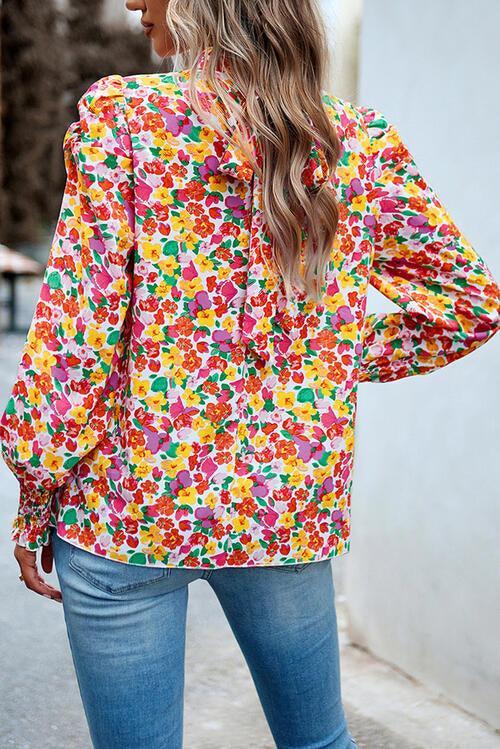 a woman wearing a colorful shirt and jeans