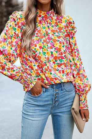 a woman wearing a colorful blouse and jeans