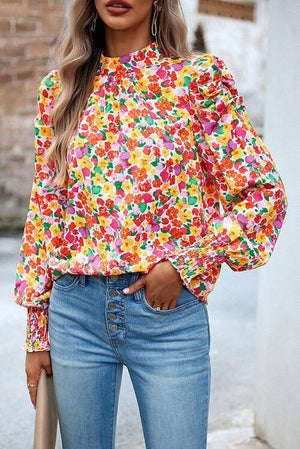 a woman wearing a colorful blouse and jeans