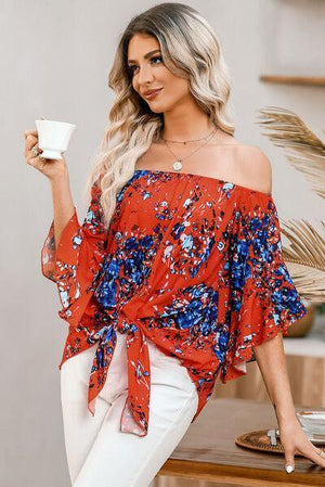 a woman in a red and blue top holding a cup