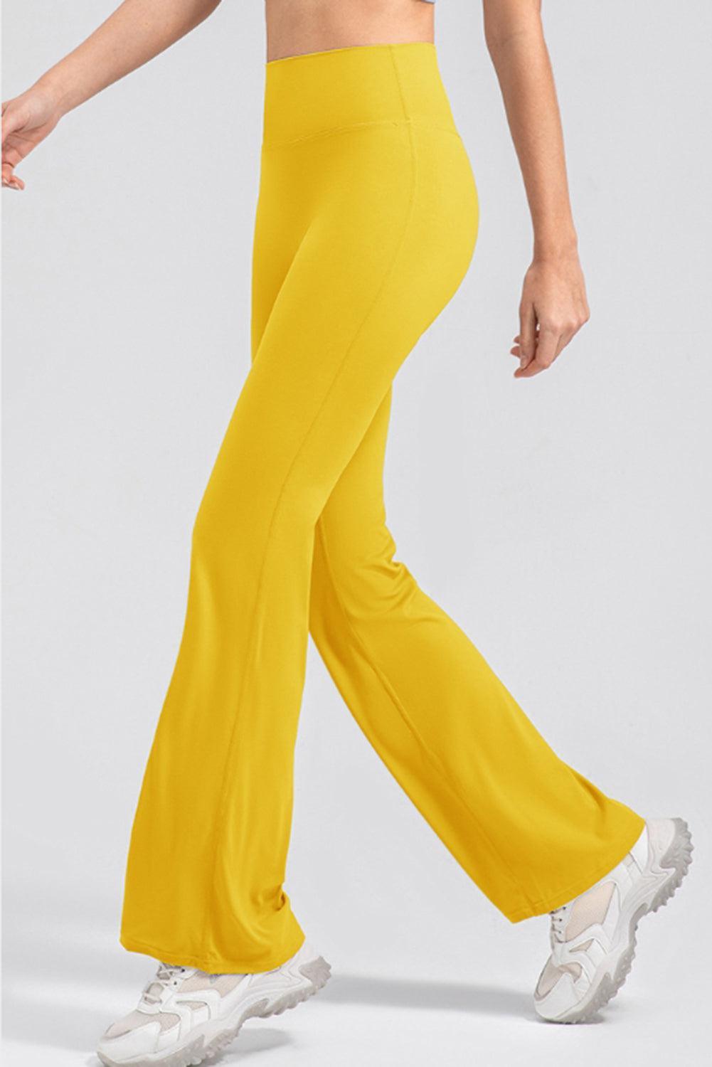 a woman in a crop top and yellow pants