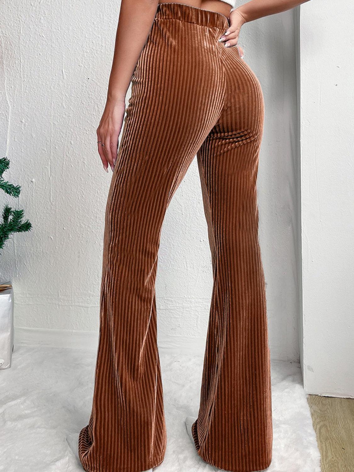 a woman in brown pants standing in a room