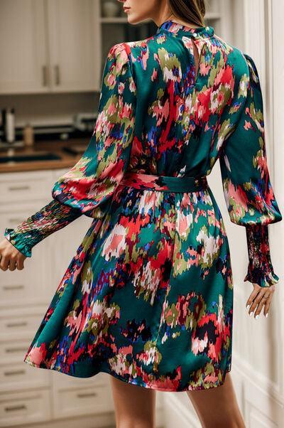 a woman standing in a kitchen wearing a green floral dress