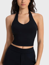 a woman wearing a black crop top and black pants