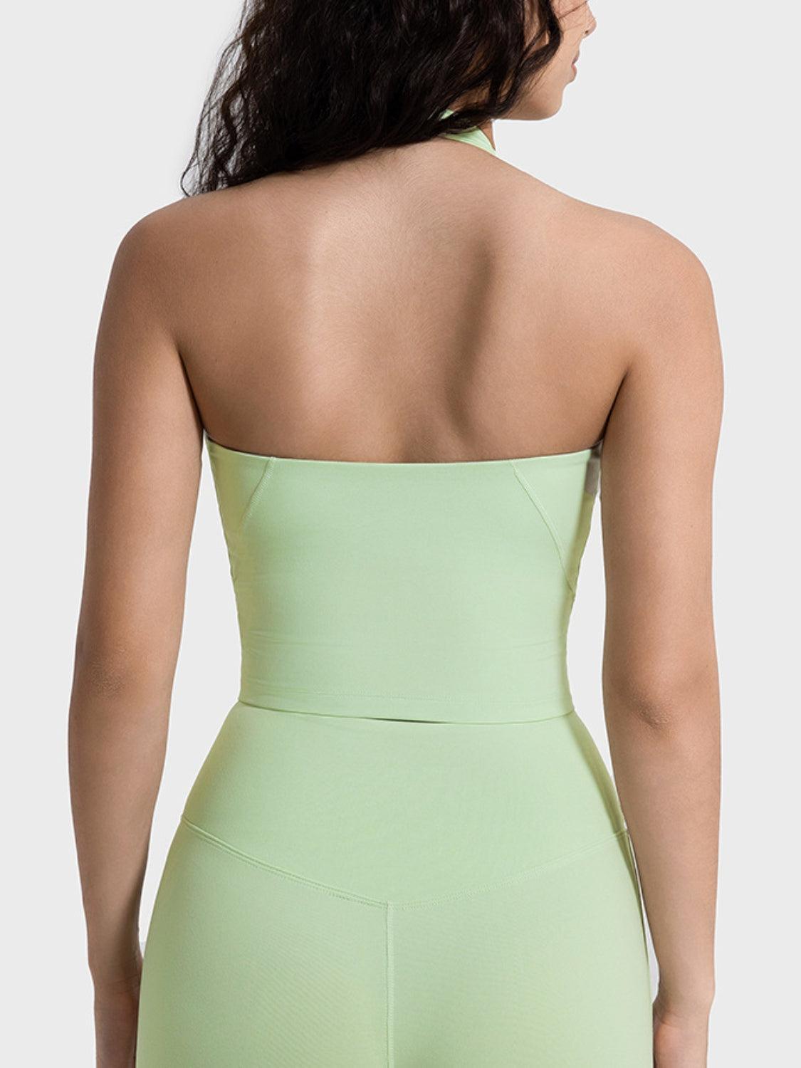 the back of a woman wearing a light green bodysuit