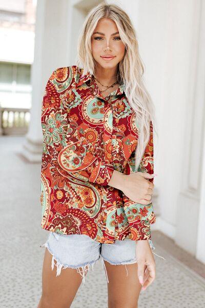 a woman wearing a red paisley shirt and denim shorts