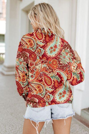 a woman wearing a red and green paisley print hoodie