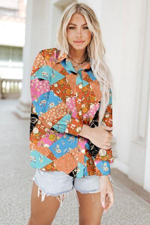 a woman wearing a colorful shirt and denim shorts