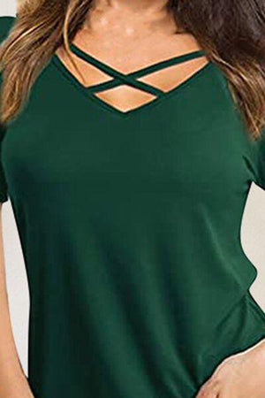 a woman wearing a green top with a cross back