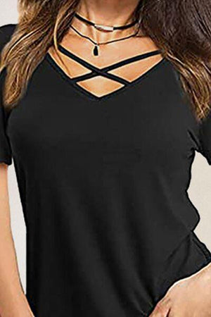 a woman wearing a black top with a cross cut neckline