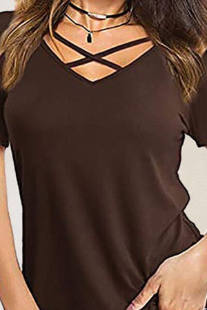 a woman wearing a brown top with a cross neck