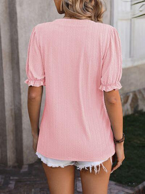 a woman wearing a pink top and white shorts