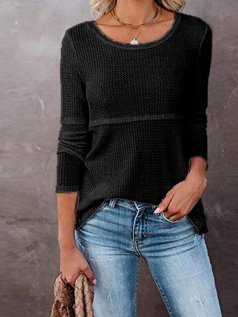 a woman wearing a black sweater and jeans