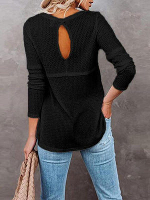 a woman wearing a black sweater with a cut out back