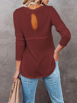 a woman wearing a red sweater with a cut out back