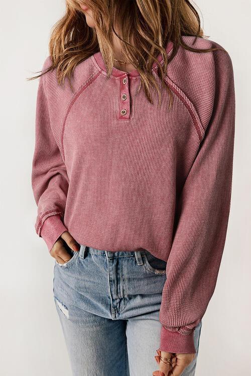 a woman wearing a pink sweater and jeans