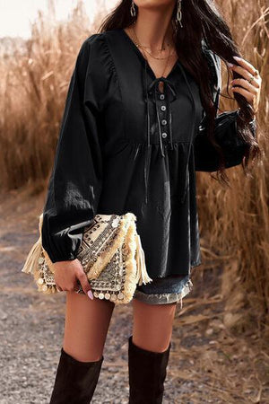 a woman in a black shirt and boots posing for a picture