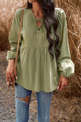 a woman wearing a green blouse and ripped jeans