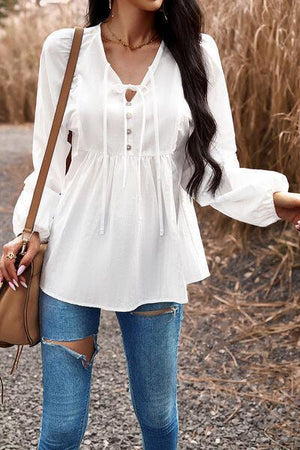 a woman in ripped jeans and a white top