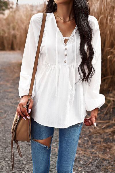 a woman wearing ripped jeans and a white blouse