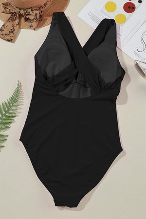 a black one piece swimsuit sitting on top of a table