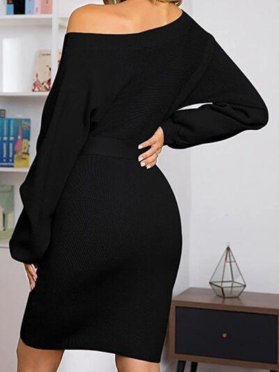 a woman wearing a black off the shoulder dress
