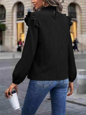 a woman wearing a black top and jeans