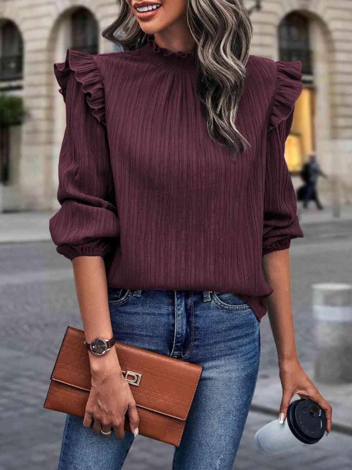 a woman wearing a burgundy top and jeans