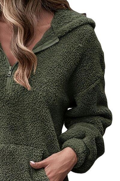a woman wearing a green hoodie and jeans