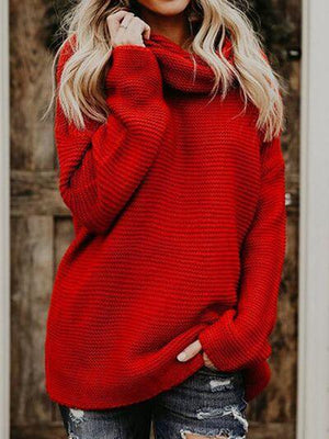 a woman wearing a red sweater and ripped jeans