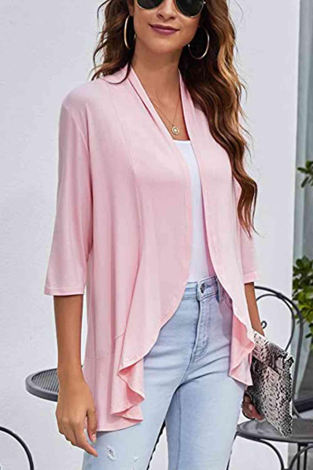 a woman wearing a pink top and jeans