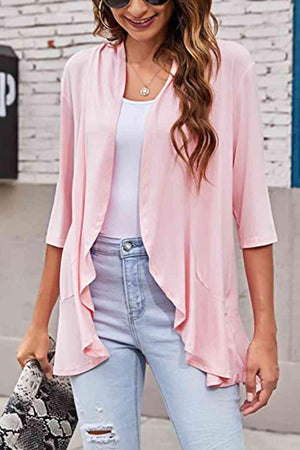 a woman wearing a pink cardigan and ripped jeans