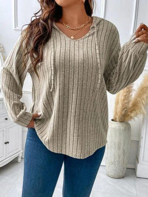 a woman wearing a tan sweater and jeans