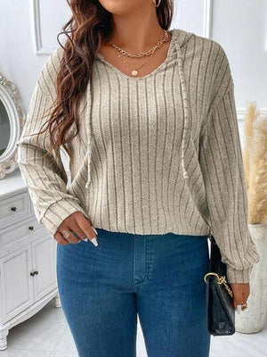 a woman wearing a beige sweater and jeans