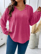 a woman wearing a pink sweater and jeans