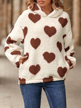 a woman wearing a sweater with hearts on it