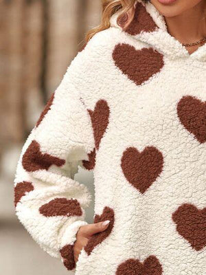 a woman wearing a sweater with hearts on it