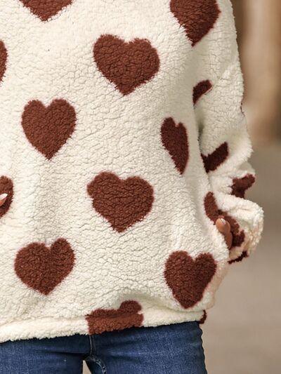 a woman wearing a sweater with hearts on it